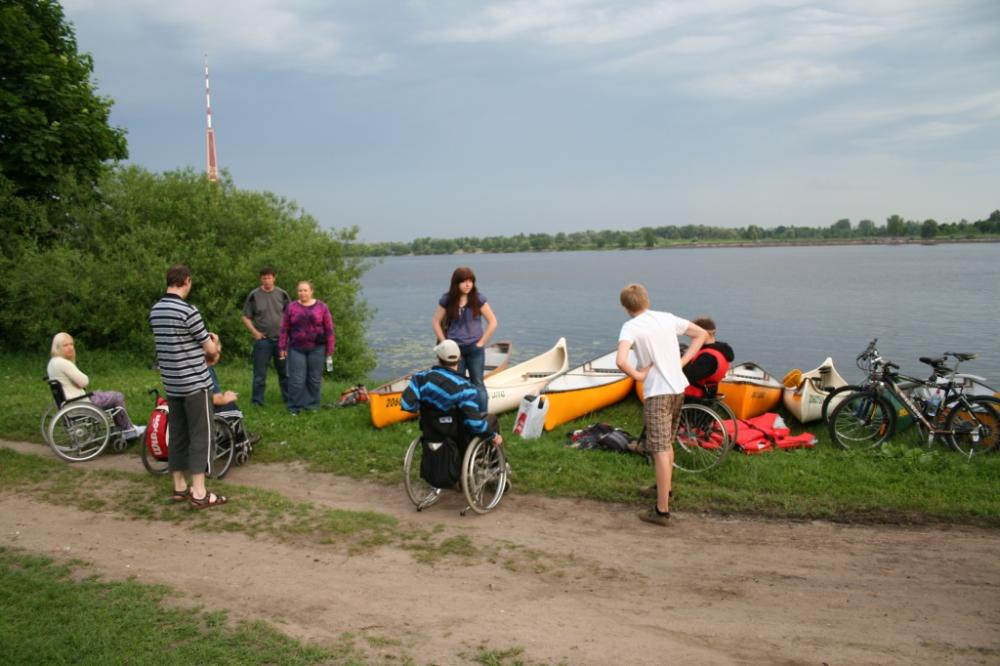Dalībnieki ar laivām pulcējas Daugavas krastā