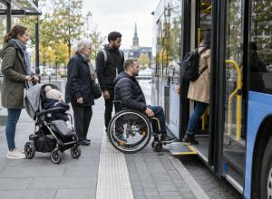 Riteņkrēsla lietotājs kopā ar citiem pasažieriem iekāpj zemās grīdas autobusā