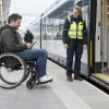 Stacijas darbiniece sagatavo rampu pasažierim riteņkrēslā pie vilciena durvīm