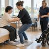 Aprūpētāja mācību dalībniece vingrina drošu pārsēšanos instruktora vadībā