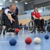 Bočas sportists met sarkanu bumbu mērķa virzienā iekštelpu sacensību laukumā