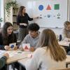 Skolotāja un pedagoga palīgs atbalsta skolēnus kopīgā uzdevumā ar vizuālām kartītēm