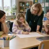 Skolniece riteņkrēslā kopā ar ģimeni un skolas speciālistiem pārrunā mācību plānu klasē.