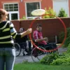 Sportiste ratiņkrēslā met disku caur apli