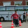 Sportists ratiņkrēslā pārvietojas starp konusiem