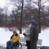 Dalībnieki apspriež karti uz parka soliņa